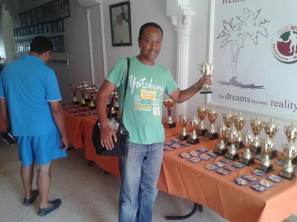 Amama Tarik devant les trophées d’un tournoi de tennis